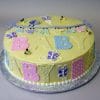 The BB-018 is a round yellow cake with pastel BABY letters, small bees, butterflies, and a purple banner, presented on a silver cake board.