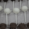 CO-032 Chocolate Cake Pops—rows of cake pops on sticks, coated in dark, white, and milk chocolate with decorative chocolate drizzle, arranged on parchment.
