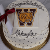 Round cake with white frosting, black polka dots, and "Congratulations Makayla" on top. Features the Weymouth High School wildcat logo with a large W and a rolled diploma tied with a red ribbon. Product: GC-001M Weymouth High School.