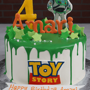 The CB-038 Toy Story cake features green icing, star decorations, a yellow number 4, an orange Amari topper, a Buzz Lightyear figure, and a "Happy Birthday Amari" plaque.