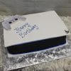 The CB-011L is a PlayStation 5 console-shaped birthday cake with a matching edible controller on top, “Happy Birthday” in blue icing, and sits on a silver decorative board.