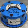 The CB-011M is a round blue birthday cake featuring PlayStation controller buttons, a controller topper, "Happy Birthday" in black icing, and a white fondant panel with the PS5 logo on the side.