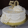 AN-023: White frosted cake with a gold “50” topper, white icing roses, gold script “Happy Anniversary Mom & Dad,” and gold board. Brick wall background.
