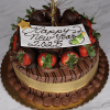 The NY-008 Chocolate Chocolate cake features chocolate-dipped strawberries, a gold ribbon, a white plaque with "Happy New Year 2025" in chocolate, festive gold accents, and is presented on a marble surface.