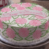 The BD-148 Pink hydrangea is a round white cake with pink flowers and green leaves, topped with a "Happy Retirement!" white banner in pink script, presented on a silver platter.