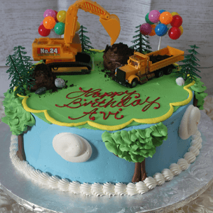 The SC-047 Construction birthday cake features a construction theme with toy excavator and dump truck, colorful balloons, small trees, and "Happy Birthday Avi" in red icing on green frosting.