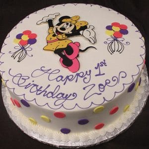 The CB-001J is a round birthday cake featuring colorful polka dots, balloons, and Minnie Mouse in a yellow dress, with “Happy 1st Birthday Zoe” written in purple icing.
