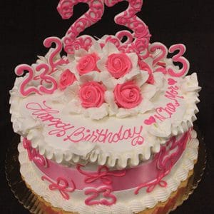 The BD-040 is a round birthday cake with pink and white icing, pink roses, multiple 23 toppers, and "Happy Birthday" plus your message written in pink icing.