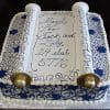 RC-090: Rectangular cake styled as a Torah scroll with blue and white designs, gold handles, and inscription “Mazel Tov Jack and Lily 24 Elul 5776.”.