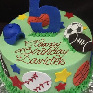 CB-017B is a round birthday cake decorated with sports-themed items, a blue cap, colorful stars, and a large blue number 5 on top. "Happy Birthday Davidek" is written in red icing on green frosting.