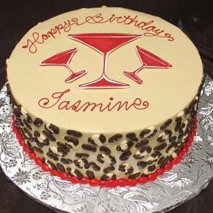BD-036D Cheetah Martini: A round birthday cake with tan frosting, chocolate spots on the sides, a red bead border, three red martini glass designs on top, and "Happy Birthday Jasmin" written in red icing.