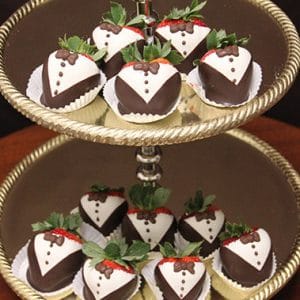 ST-002 Tuxedo Strawberries, decorated like tiny tuxedos, are elegantly arranged on both tiers of a silver tray.
