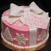 The CH-041 is a pink birthday cake adorned with white snowflakes, Christmas trees, a large white fondant bow, and a tag that says "Happy Birthday Elisabeth" in pink script.