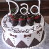 The FD-002 is a round cake topped with chocolate-dipped strawberries, “Dad” in white chocolate, and “Happy Fathers Day” in script. Brown bows and zigzag patterns decorate the sides.