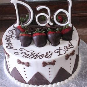 The FD-002 is a round cake topped with chocolate-dipped strawberries, “Dad” in white chocolate, and “Happy Fathers Day” in script. Brown bows and zigzag patterns decorate the sides.