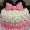 The CB-001E is a round cake with white and pink rosette frosting, black fondant ears, and a large pink bow resembling Minnie Mouse, displayed on a silver-patterned board.