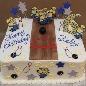 CB-013A: Rectangular birthday cake featuring a bowling alley design with Minion decorations, “Happy Birthday Felix,” a large blue and yellow 6, plus bowling pins, balls, and star accents.