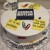 A round BD-136 cake features colorful paperclips, quote post-it notes, a Dunder Mifflin Paper Company logo, and a "World’s Best Boss" mug. The cake reads: "Happy Birthday Grandpa, We love you!.