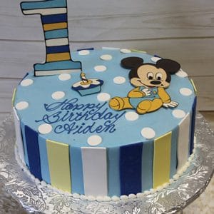 The CB-002B cake features blue and white polka dots, a striped number one, a cartoon mouse topper, a small candle, "Happy Birthday Aiden" in blue icing, and side stripes in blue, yellow, and white.