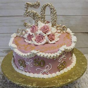 The BD-039 is a pink and white round cake with roses and gold accents, featuring the number 50 on top and sides—perfect for a 50th birthday or anniversary. It sits on a gold board.