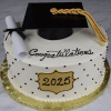 The GC-0005 is a round graduation cake with white icing, black dotted accents, and a gold-bordered “2025” plaque. It’s topped with a black graduation cap, gold tassel, diploma, and “Congratulations” in black icing.