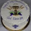 RC-001K is a round white cake featuring a gold chalice, wheat, grapes, and leaves, with “Happy 1st Holy Communion Leah. God Bless you.” on top. Purple crosses and white designs decorate the sides.